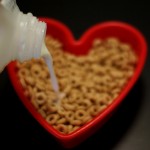 pouring milk into a red heart-shaped bowl of Cheerios on www.adventuresinexpatland.com