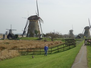 Man and dog in front of Kinderdijk windmill on www.adventuresinexpatland.com