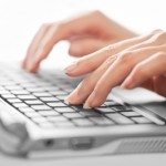 woman's hands typing on keyboard at Adventures in Expat Land